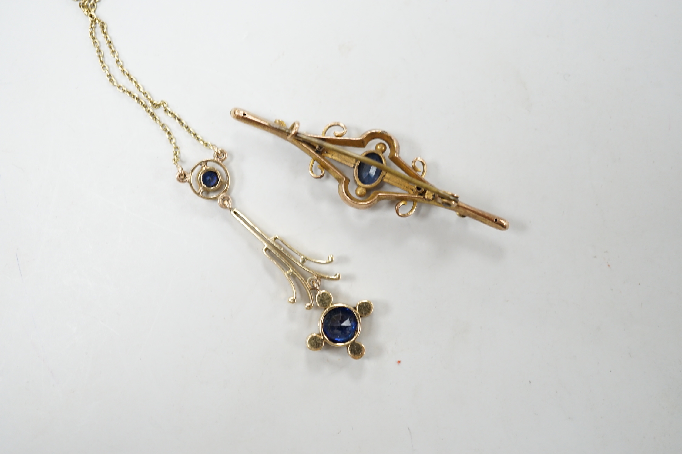 An Edwardian 15ct gold, sapphire and seed pearl set drop pendant necklace, overall 52cm, gross weight 4.5 grams and one other yellow metal and gem set bar brooch.